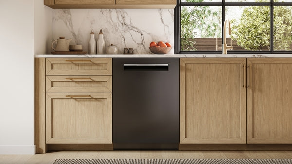 Black built-in dishwasher integrated into light wood kitchen cabinetry with marble backsplash and gold faucet fixture