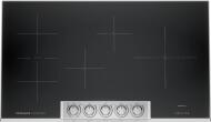 Black induction cooktop with five stainless steel control knobs and multiple cooking zones for precise heat control