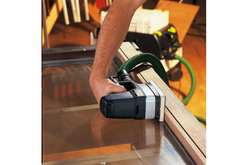 Person using a handheld sander on a wooden window frame in a woodworking tools and home improvement setting