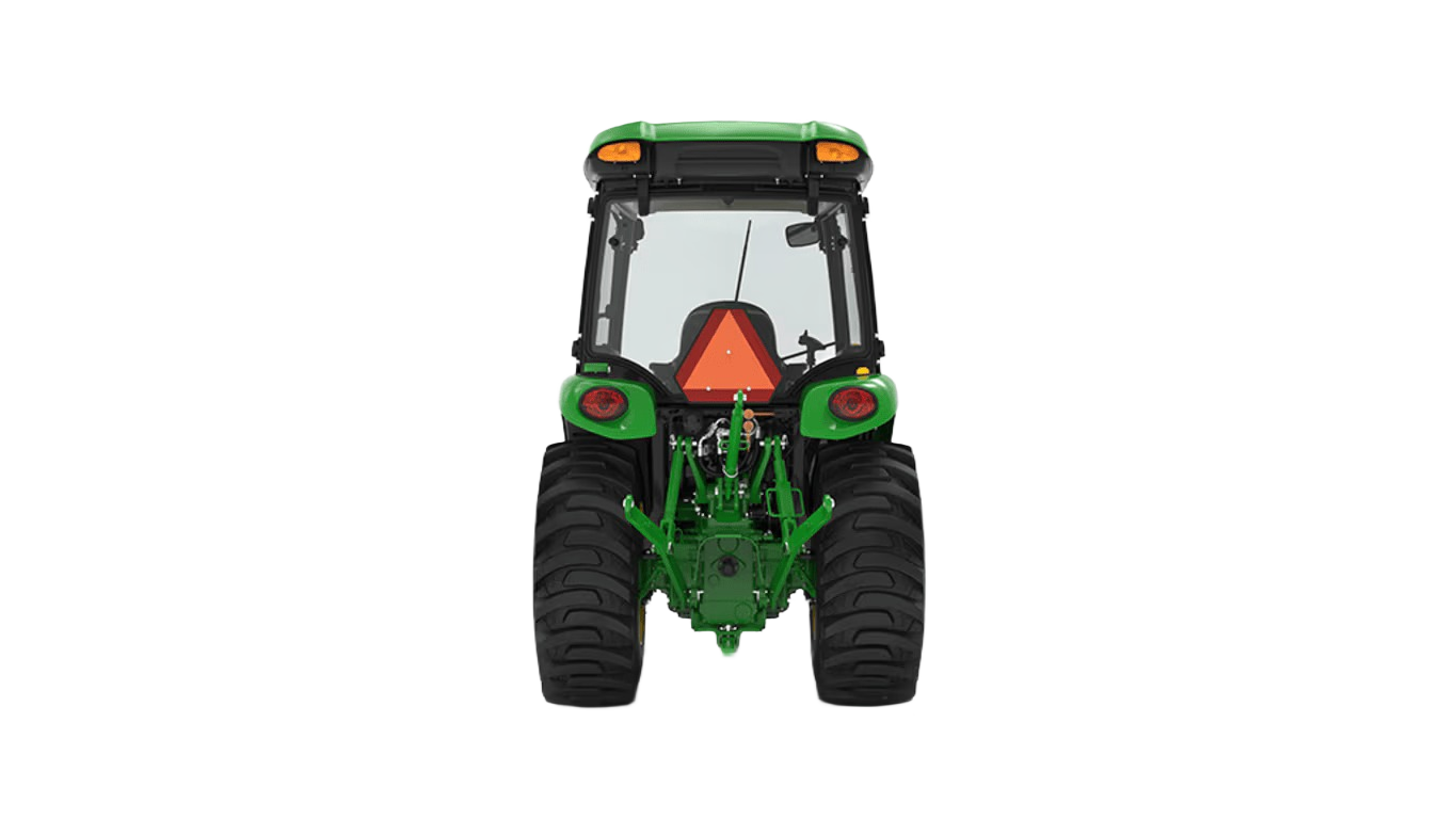 Rear view of green John Deere compact tractor with snow cab and standard seat for tools and home improvement tasks