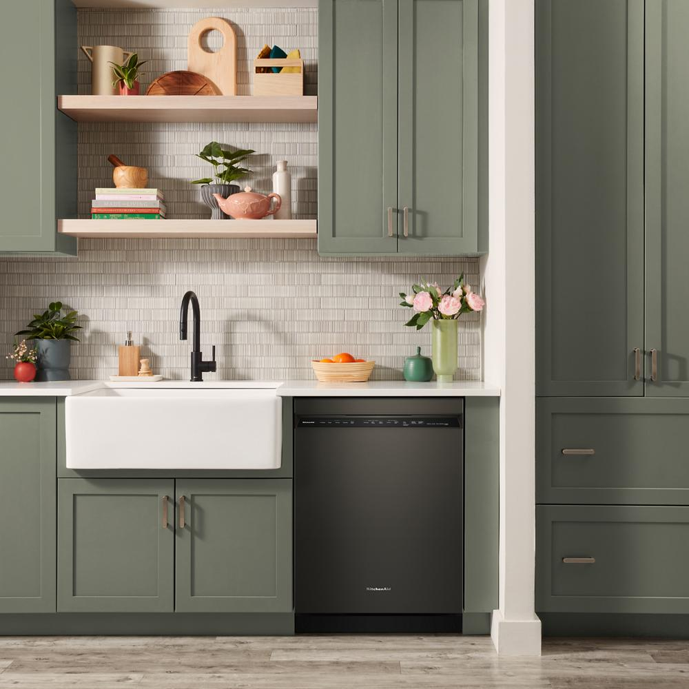 Modern kitchen with green cabinetry, white farmhouse sink, and built-in black dishwasher from KitchenAid appliances collection