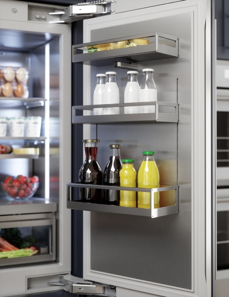 Open stainless steel refrigerator door with organized shelves holding milk, juice, and bottles in modern kitchen appliance setup