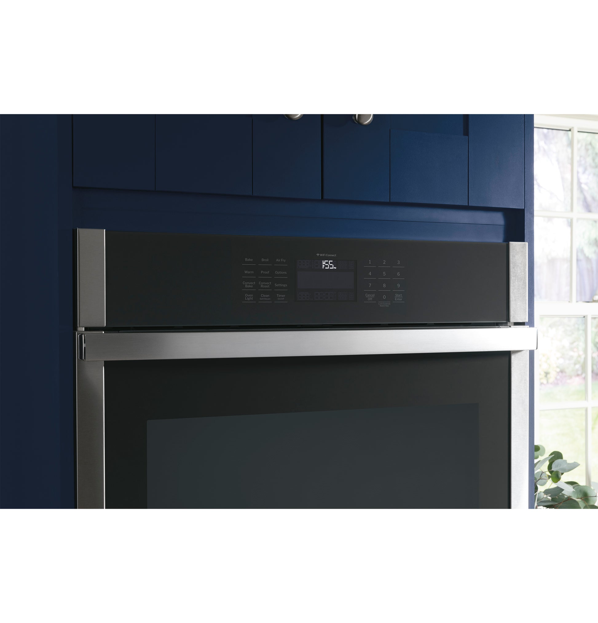 Close-up of stainless steel built-in convection single wall oven control panel with digital display in modern kitchen setting