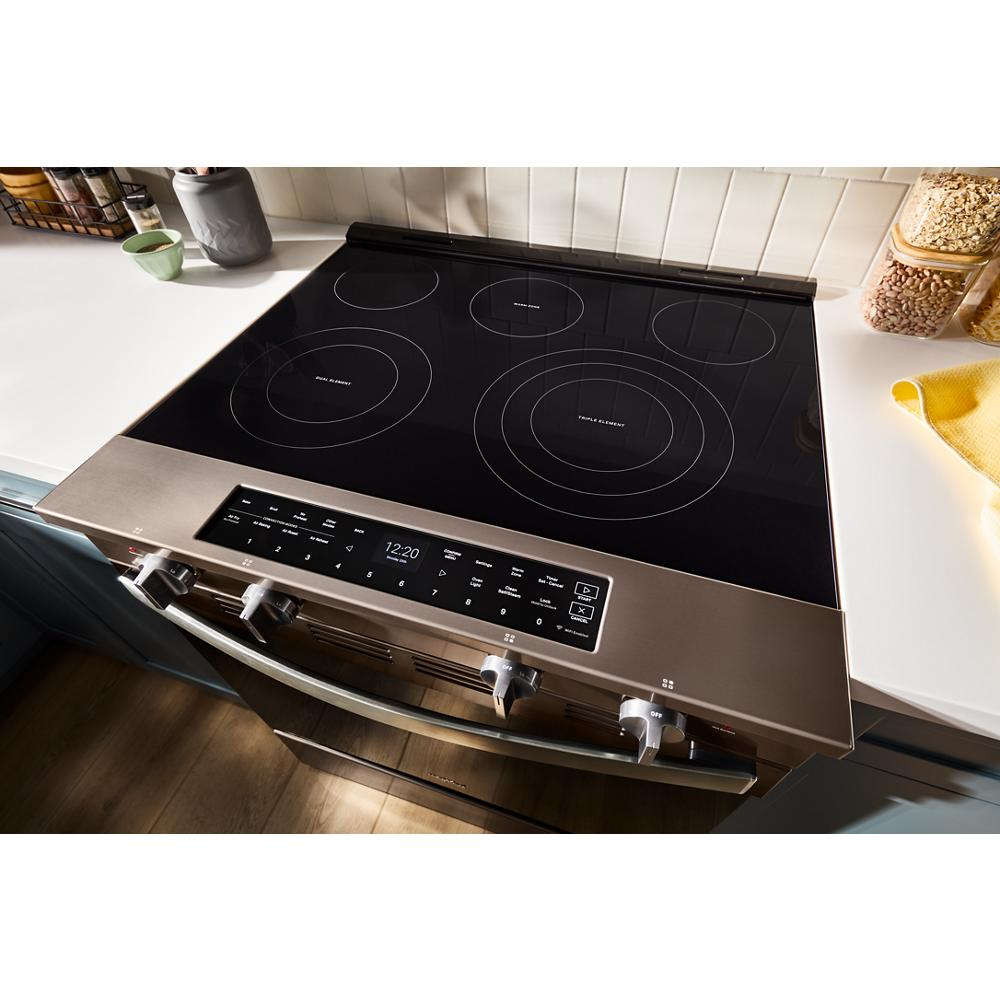 30-inch electric slide-in range with smooth black glass induction cooktop and stainless steel control panel in modern kitchen