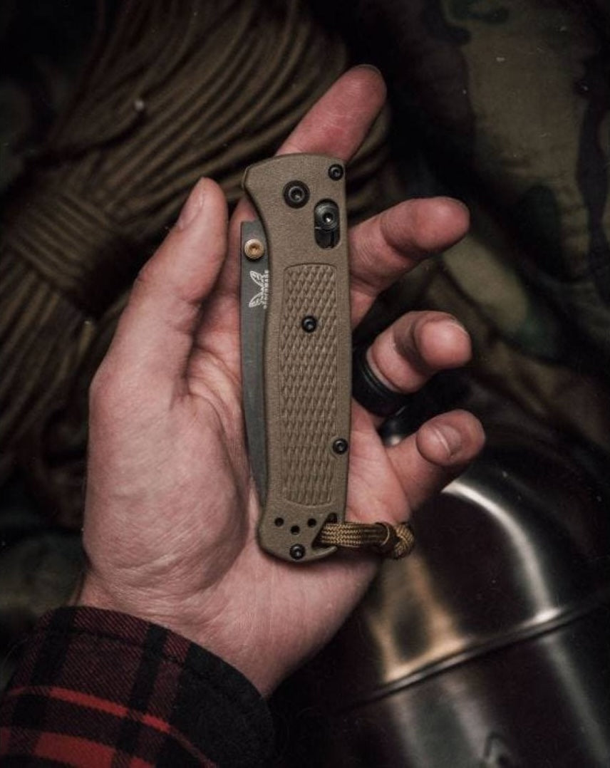 Hand holding compact folding knife with textured ranger green handle and black hardware for easy grip and carry
