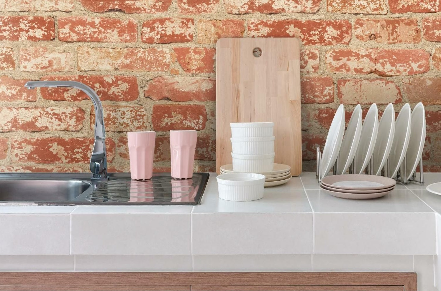 Kitchen countertop and sink with decorative stuccoed brick wall for home improvement and interior design.