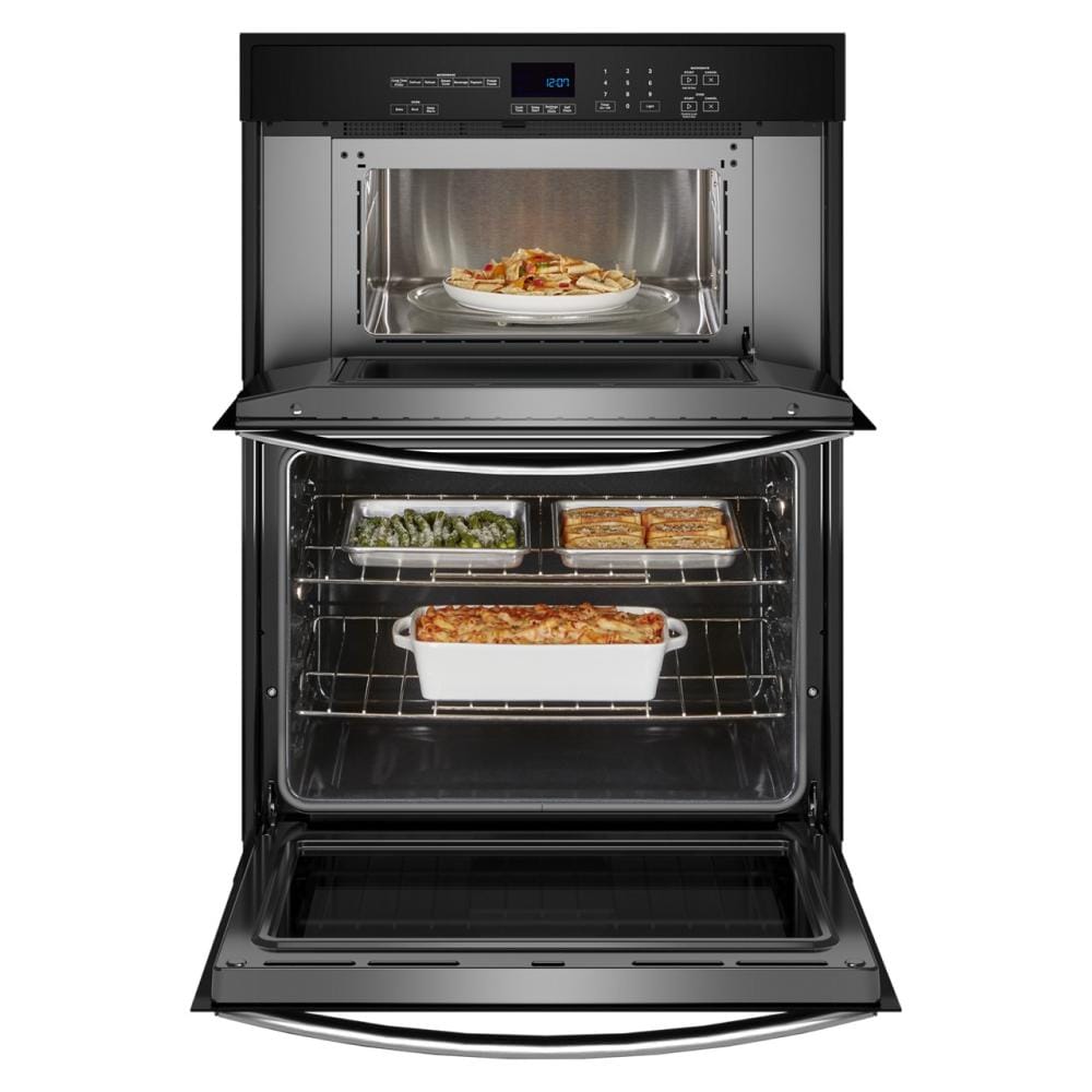 Open wall oven and microwave combo with cooked dishes inside in a modern kitchen appliance setting