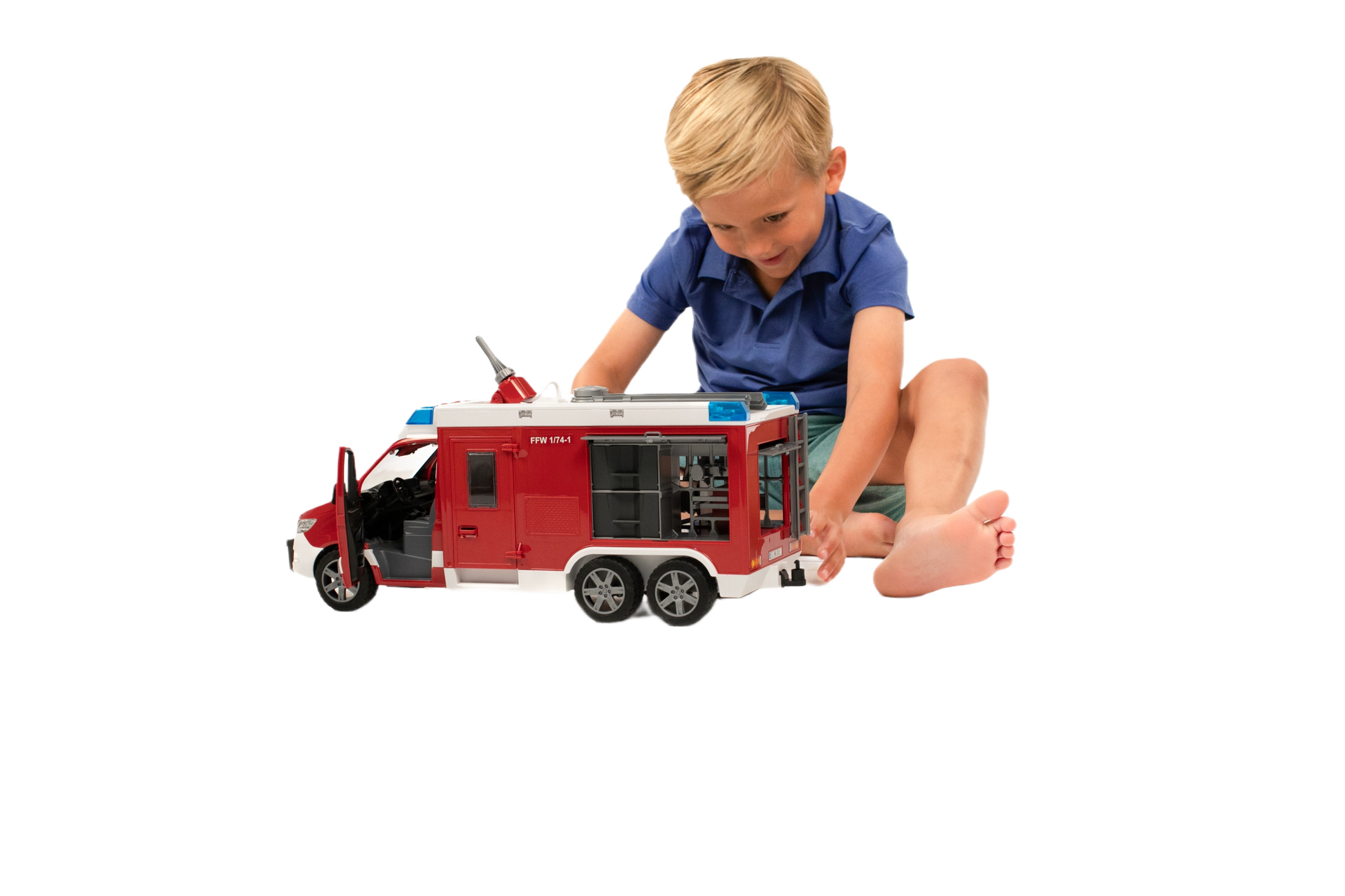 Young child playing with a detailed red and white Bruder fire engine model featuring a ladder and side compartments