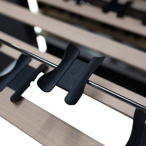 Close-up of black plastic clip securing metal rod to wooden slats in under counter wine cellar from kitchen appliances collection