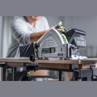 Person using Festool cordless track saw with safety kickback stop cutting wood on adjustable workbench for home improvement