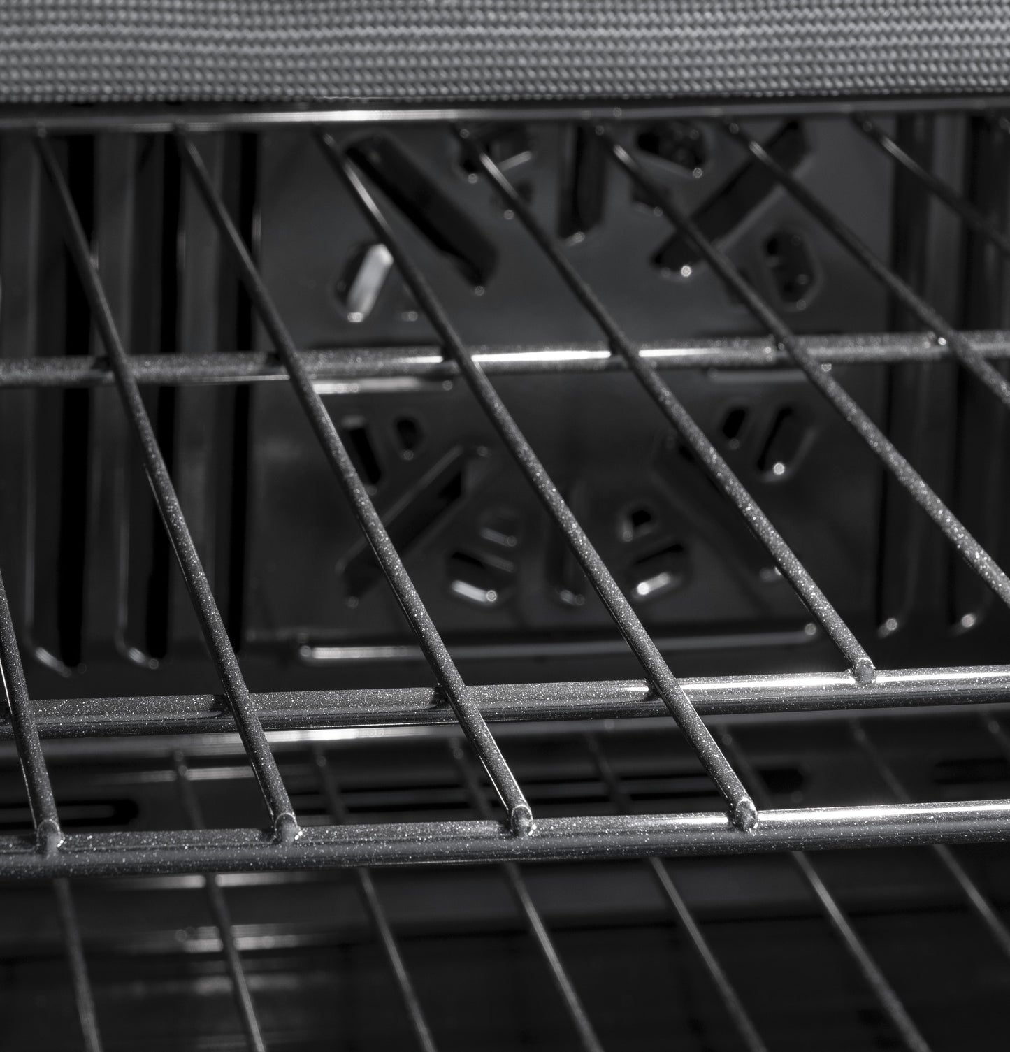 Interior view of GE built-in single wall oven showing metal racks and convection fan for even cooking airflow