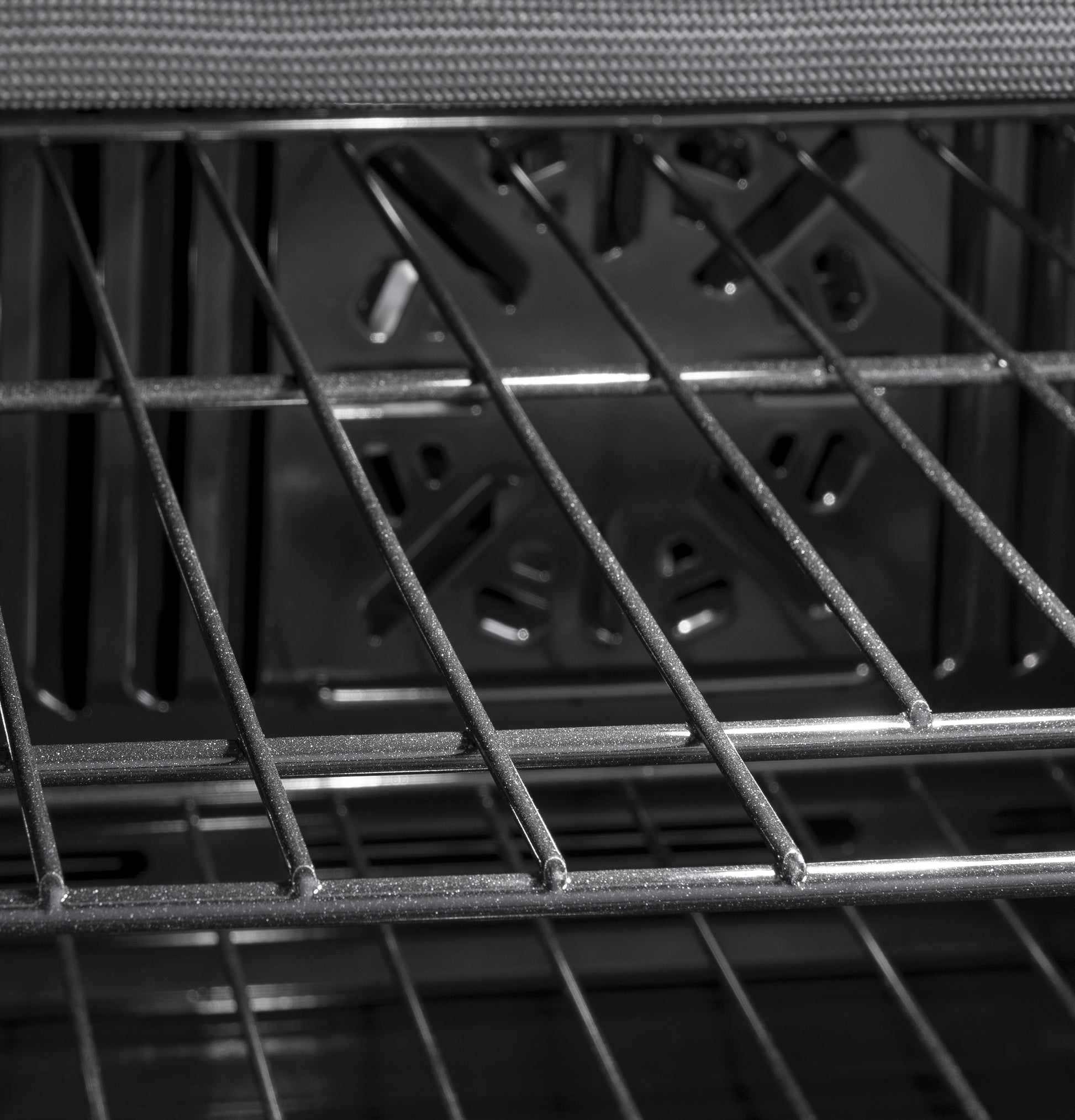 Interior view of GE built-in single wall oven showing metal racks and convection fan for even cooking airflow