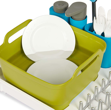Green plastic dishwashing tub with white plates and blue utensil holders for home cleaning tasks