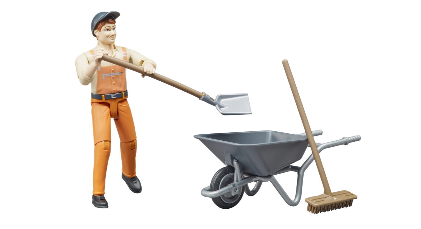 Figure of worker in orange outfit holding shovel near gray wheelbarrow with broom for home improvement playset