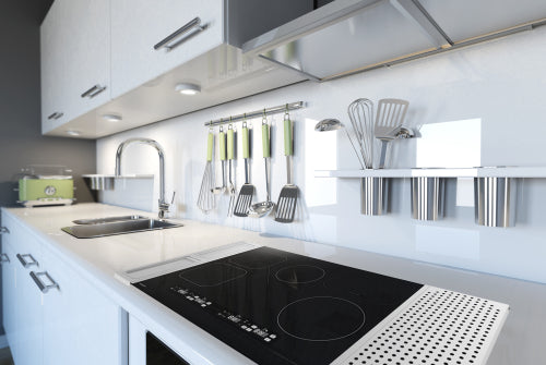 Modern kitchen countertop with sleek black induction cooktop and organized stainless steel utensil holders in home improvement collection