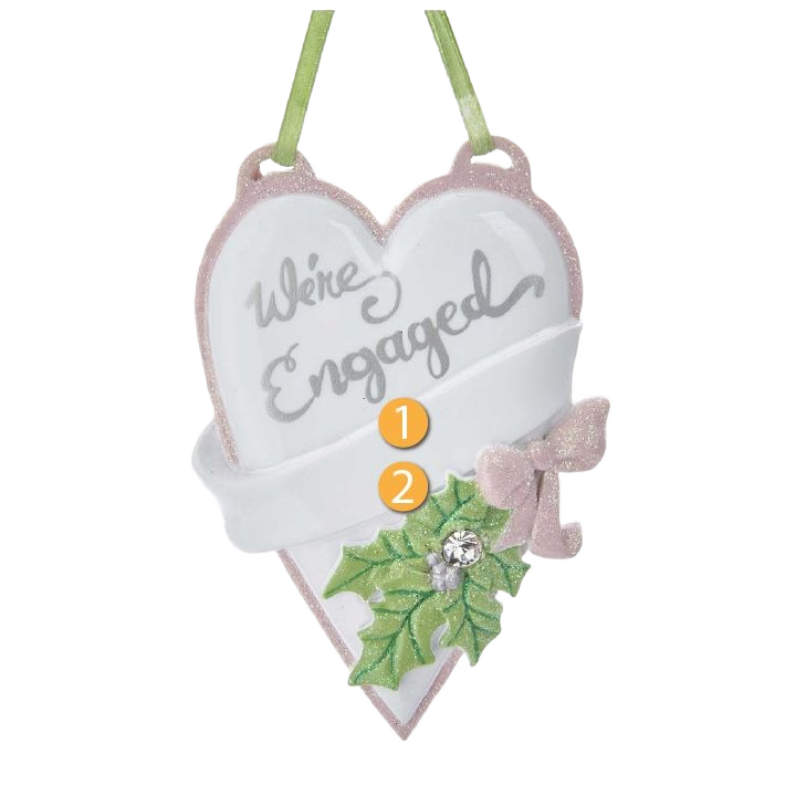 Heart-shaped personalized ornament with "We're Engaged" text, decorated with holly leaves and a pink bow for celebrations
