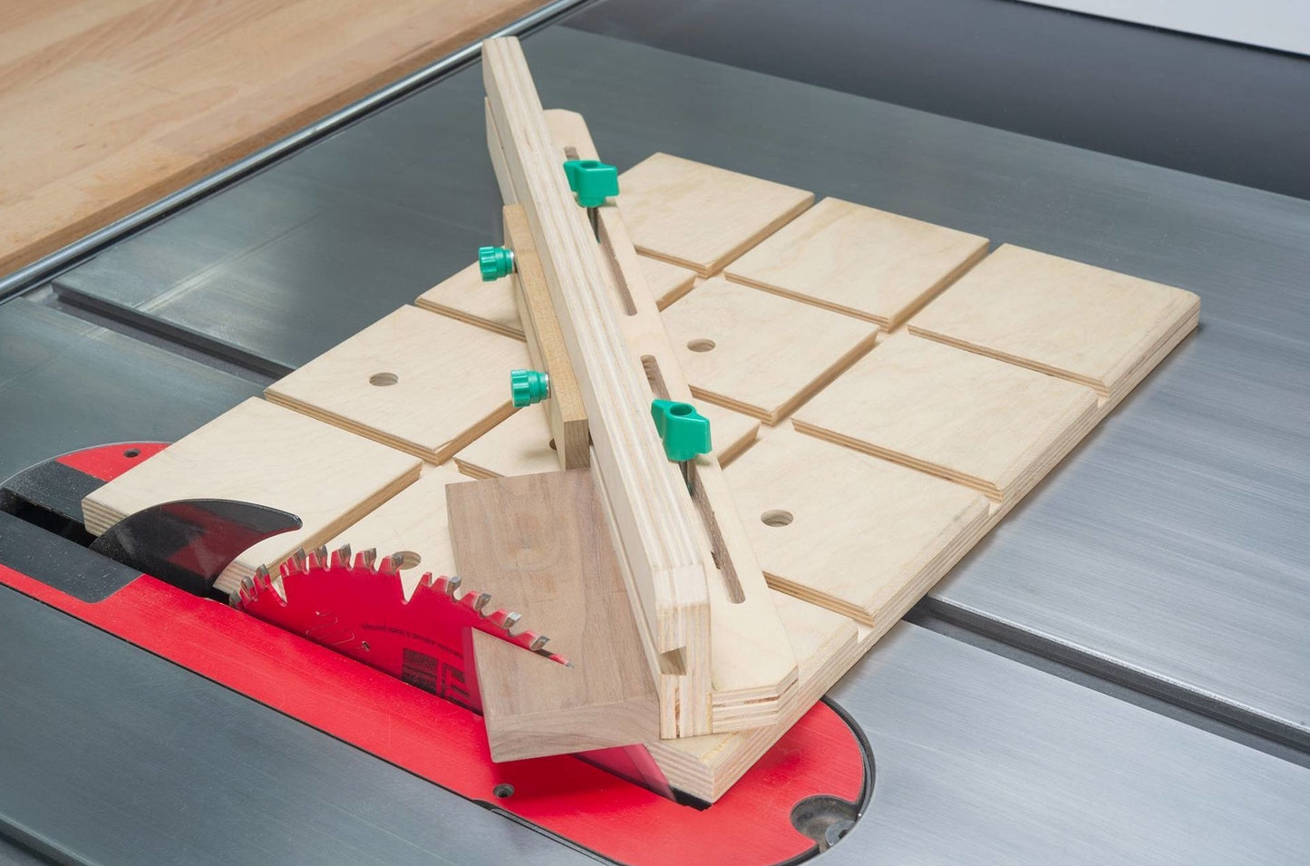 Woodworking jig with green adjustable hardware screws clamped to a table saw for precise cuts in tool accessories collection