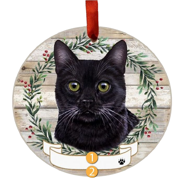 Round ornament featuring a black cat face inside a festive green wreath with red berries and a red hanging ribbon
