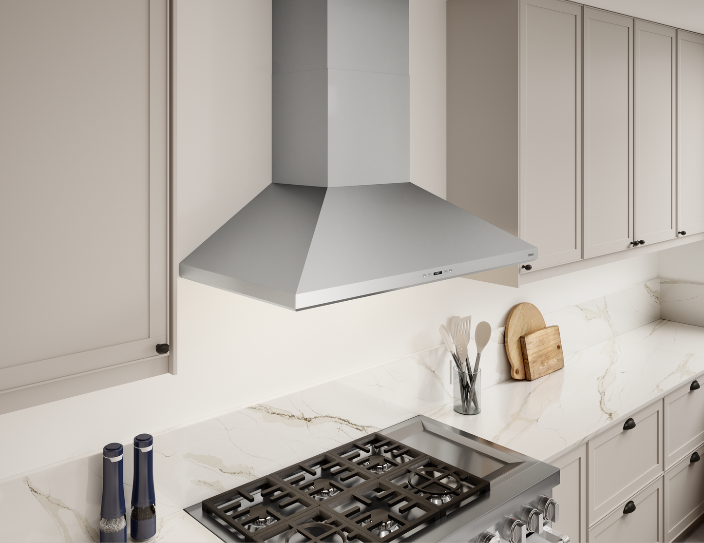 Polished stainless steel wall-mounted range hood with LED lighting above gas cooktop in modern kitchen setting