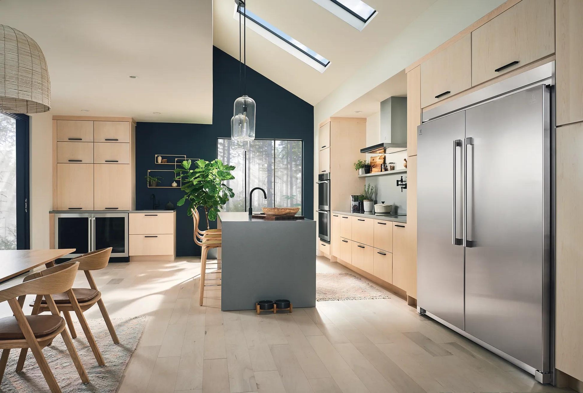 Spacious modern kitchen with light wood cabinets, large stainless steel freezer, and natural light in Appliances and Kitchen collections
