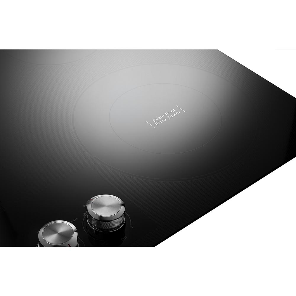 Smooth black electric cooktop with five radiant elements and metallic knob controls for kitchen appliances collection