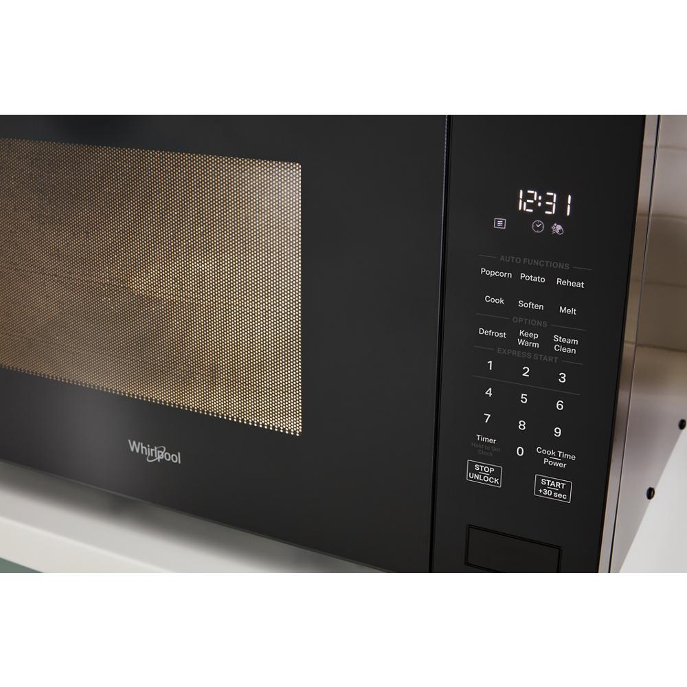 Black sensor cooking microwave touchpad with digital clock and preset auto functions in modern kitchen appliance setting