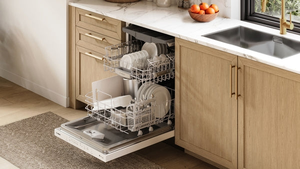 Open 24-inch white built-in dishwasher filled with dishes integrated into modern kitchen cabinetry from Bosch appliances collection