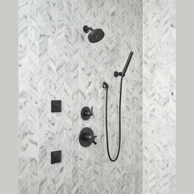 Matte black hand shower wall elbow with matching fixtures on gray chevron tile in bathroom and home improvement collections