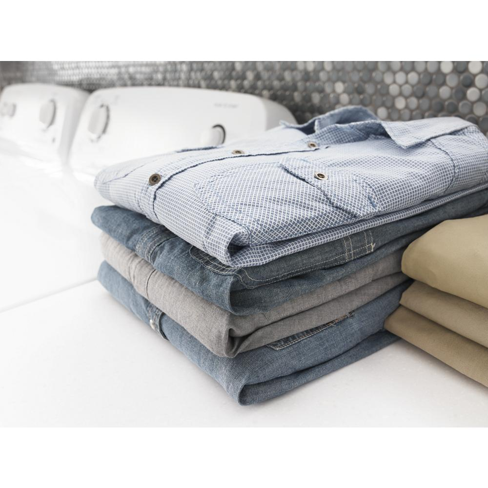 Stack of folded casual clothes on top of white electric dryer in a home laundry room setting for home improvement