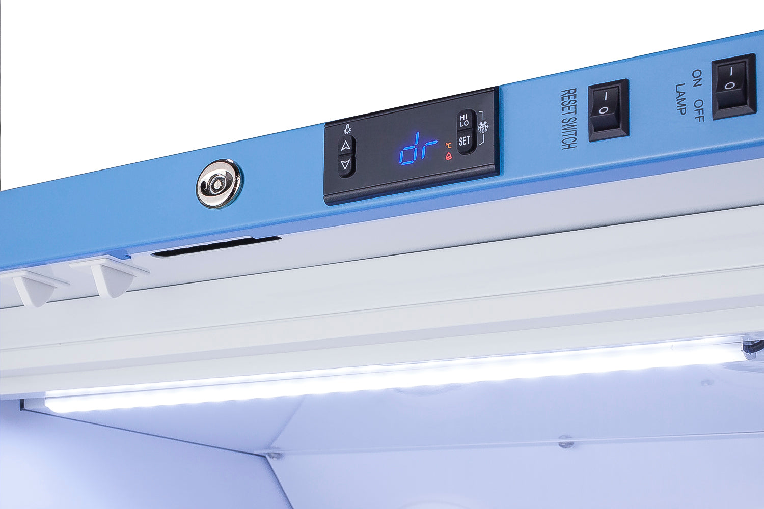 Close-up of blue control panel with digital display and switches on a white upright freezer in appliance setting