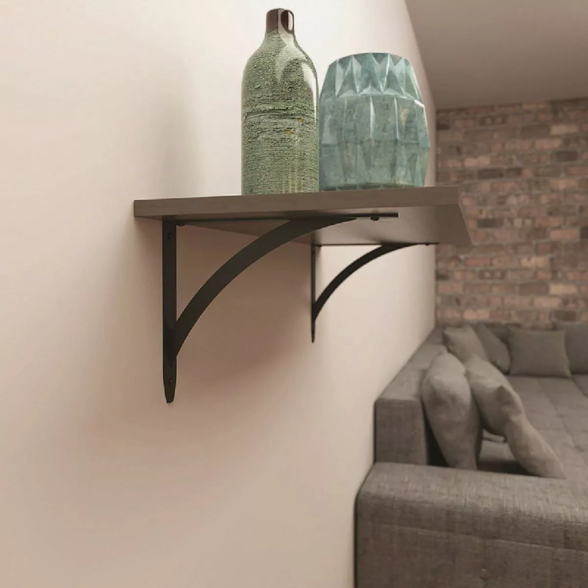 Black decorative metal bracket with curved support holding a wooden shelf in a modern living room setting