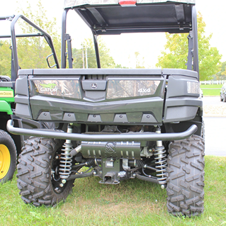 Front view of camo mid-size utility vehicle highlighting rugged tires, suspension, and protective bumper guard outdoors