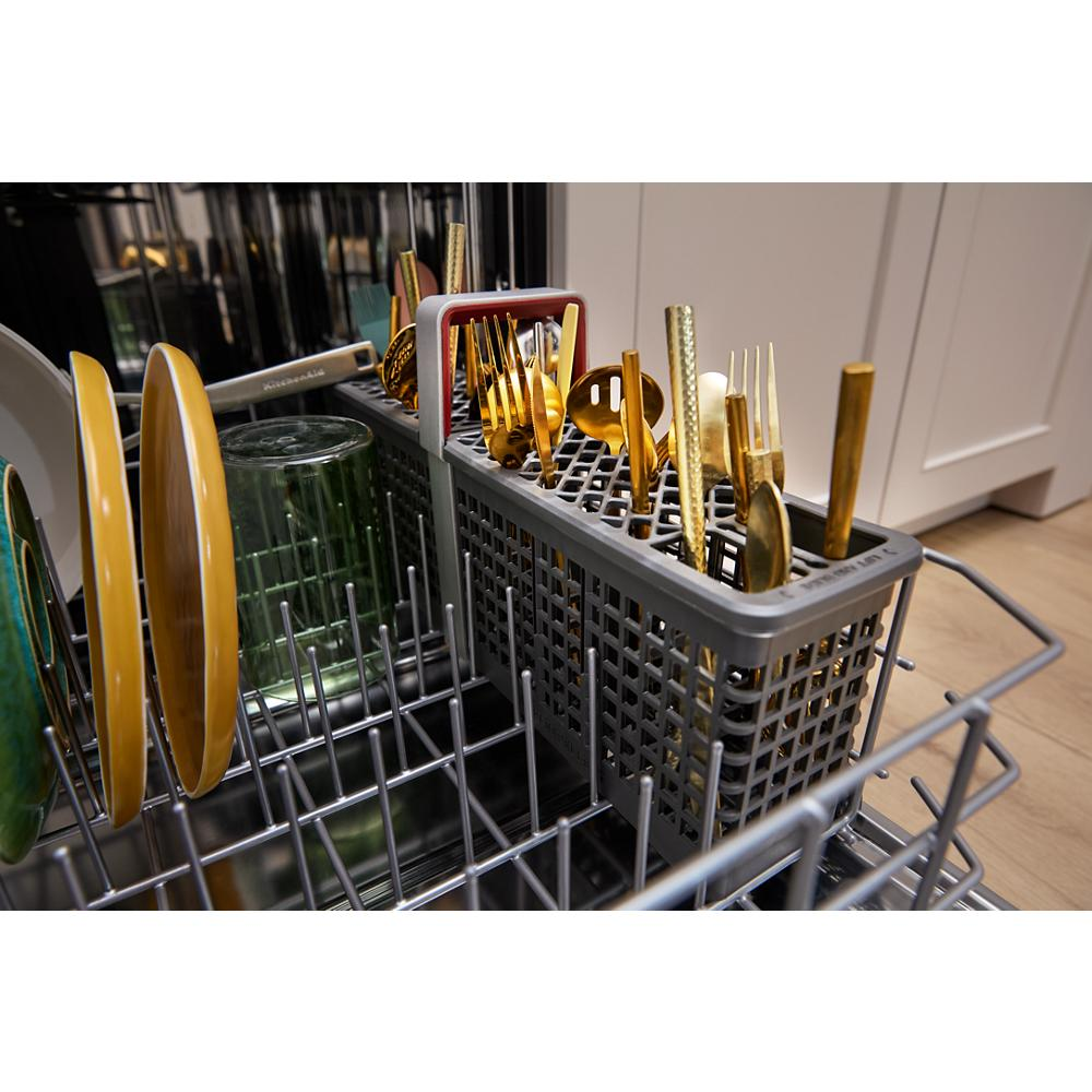 Cutlery with gold finish in utensil holder and plates inside lower rack of stainless steel dishwasher from KitchenAid collection