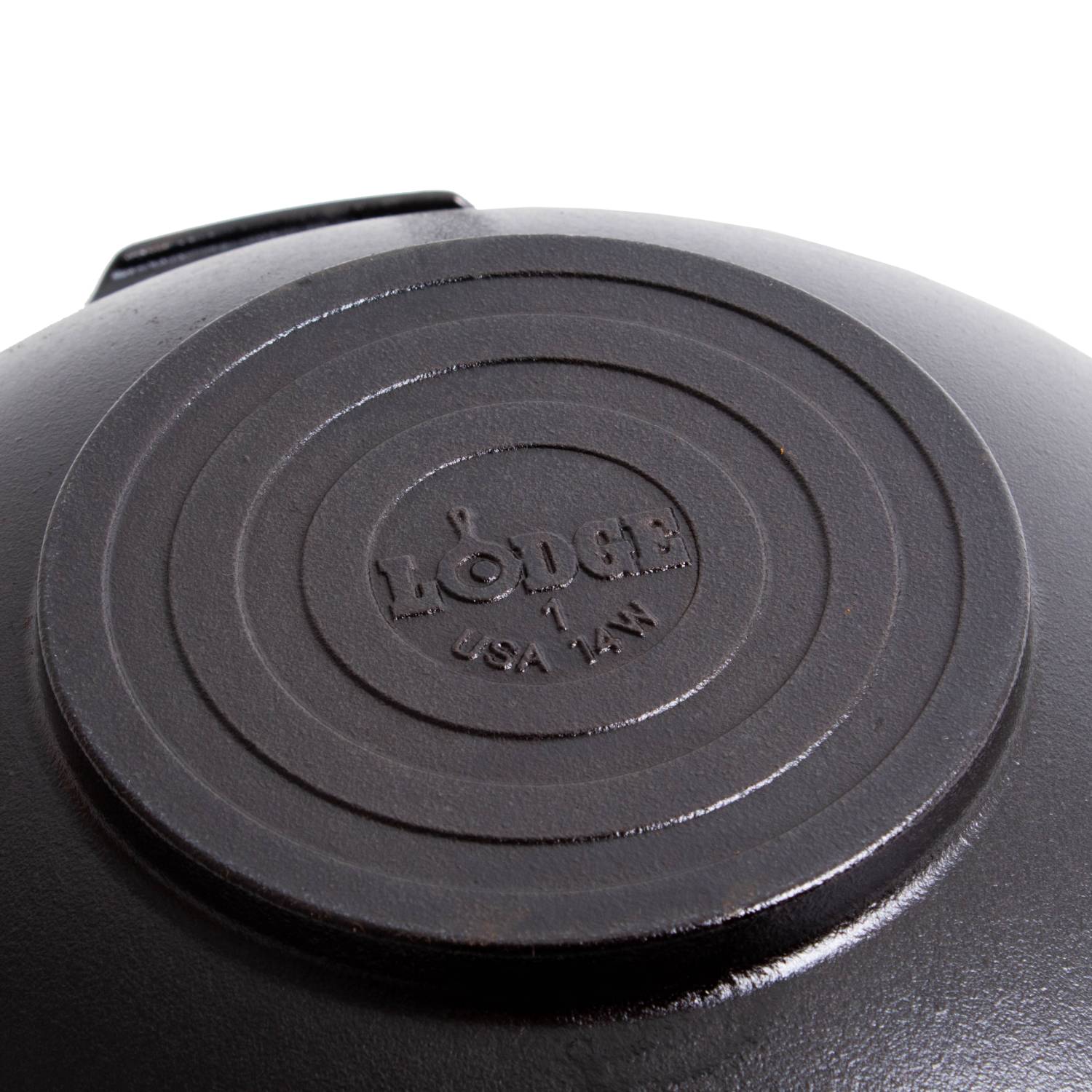 Close-up of the underside of a black cast iron wok with embossed brand mark for kitchenware collections under $100