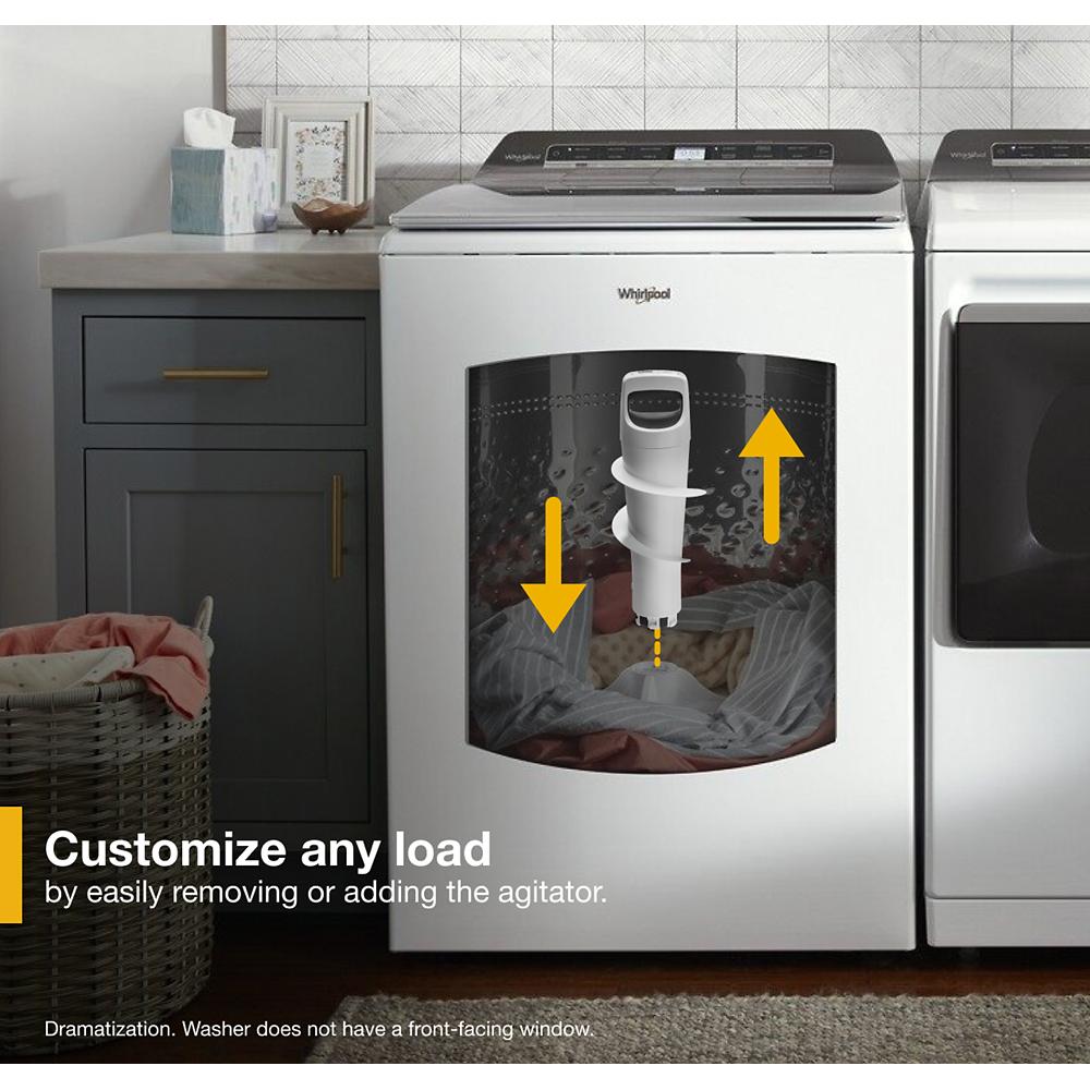 White Whirlpool top load washer with removable agitator shown in modern laundry room with gray cabinets and basket