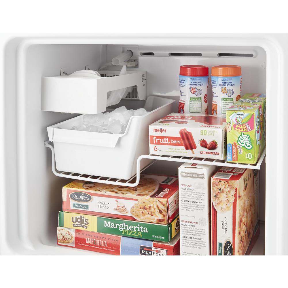 Inside view of small top freezer refrigerator fully stocked with frozen foods, ice bin, and adjustable shelving in appliances category