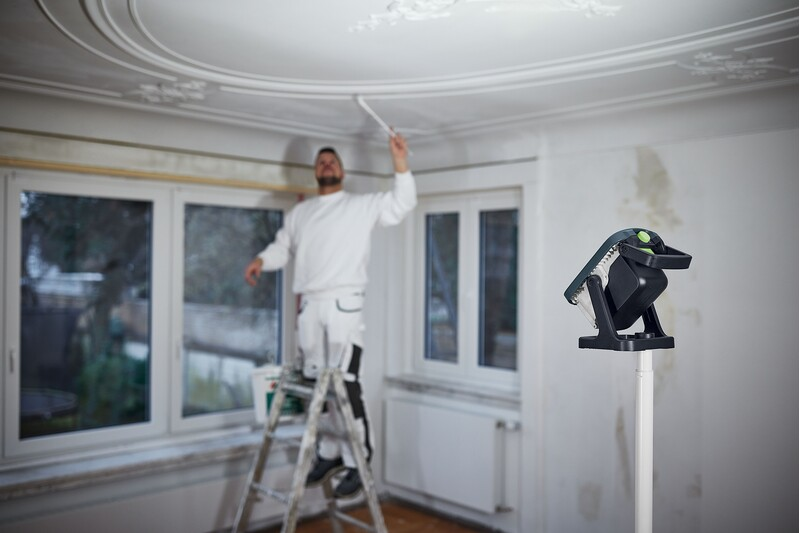 Adjustable tripod with locking pin supporting work light for home improvement and power tool accessory setups