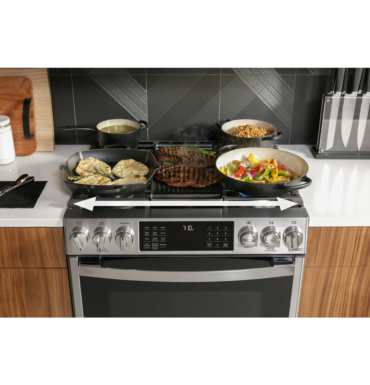 Fingerprint-resistant stainless steel slide-in gas range with front controls cooking various dishes in a modern kitchen