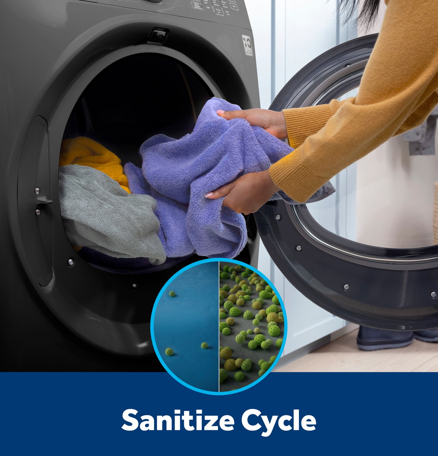 Person loading soft towels into a matte black front load electric dryer with sanitize cycle feature shown