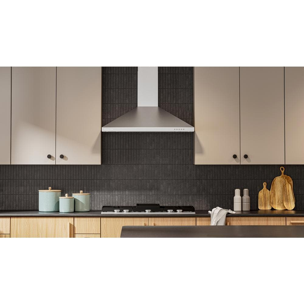 Modern wall-mount canopy hood with sleek stainless steel finish above gas cooktop in contemporary KitchenAid kitchen setting