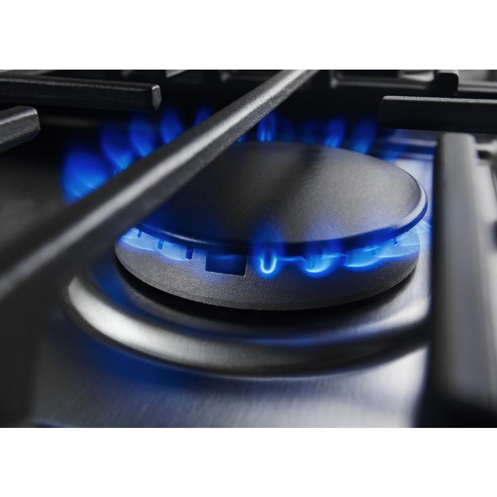 Close-up of blue flame burning on a stainless steel gas burner from KitchenAid appliance collection