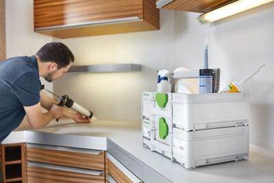 Stacked white and green modular Festool toolboxes holding sealants and workshop supplies for jobsite organization