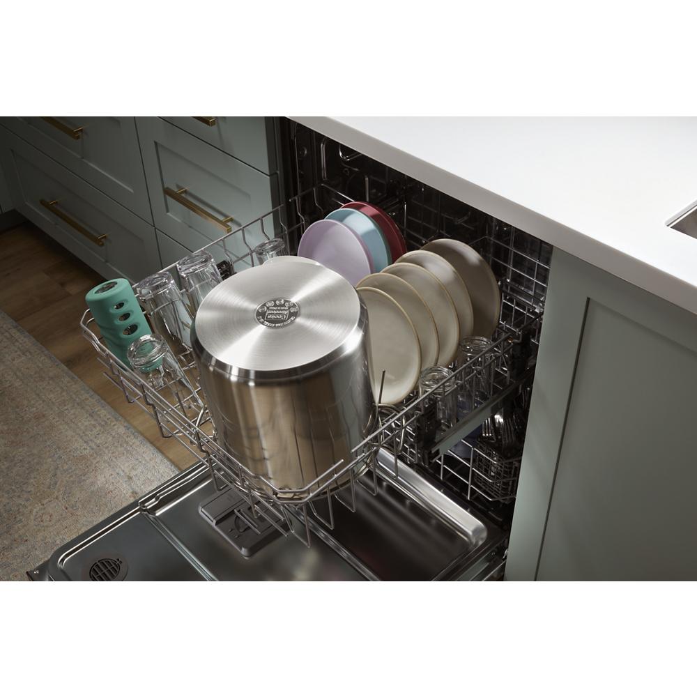 Open dishwasher loaded with large stainless steel pot, dishes, glasses, and cups in modern kitchen setting