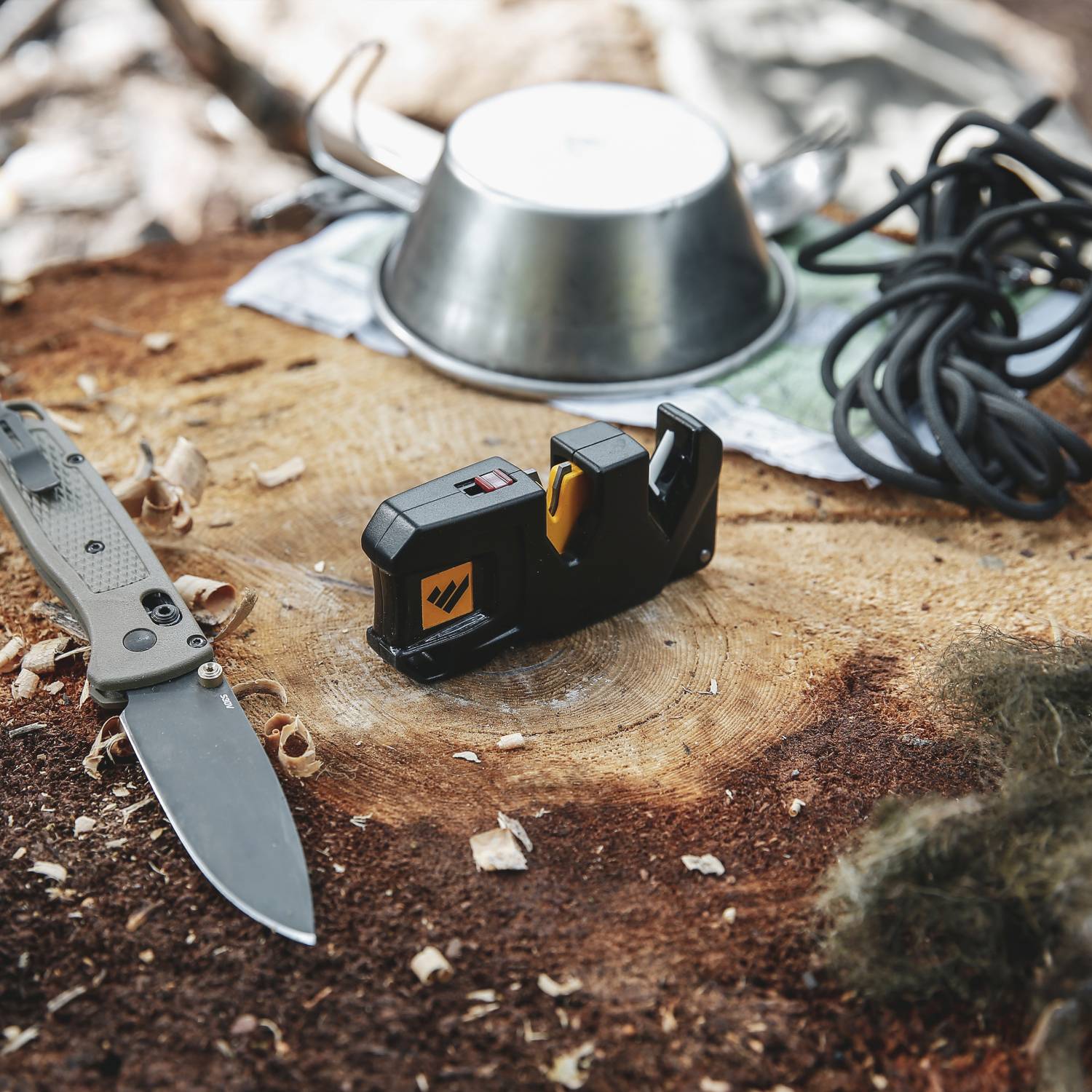 Compact Work Sharp sharpening tool with electric cord beside folding knife on wooden surface with wood shavings