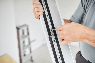 Person attaching Festool guide rail connectors to white saw tracks for woodworking and home improvement tools assembly