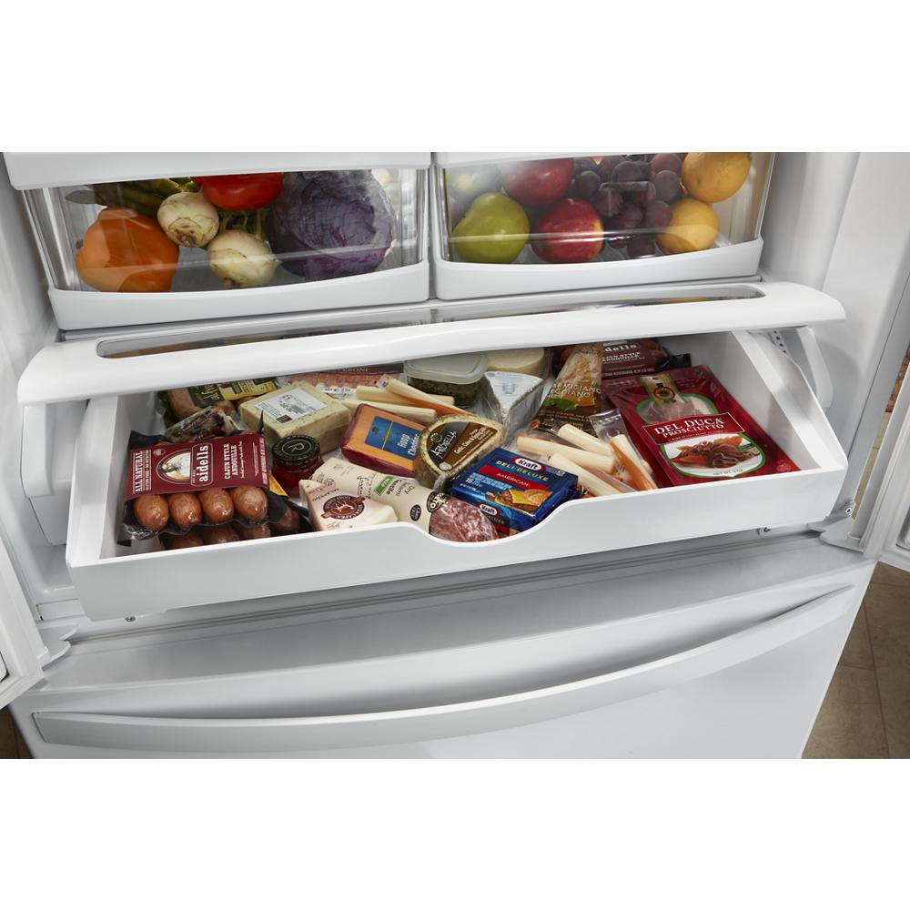 Open deli drawer inside a Whirlpool French door refrigerator with assorted packaged cheeses and meats from appliances collection
