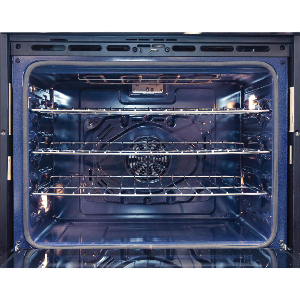 Interior view of a spacious electric oven with multiple wire racks in a modern kitchen appliance setting