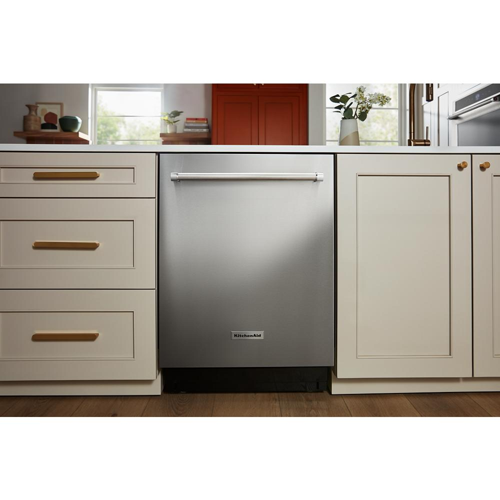 Stainless steel dishwasher with curved handle integrated into white cabinetry in modern kitchen setting