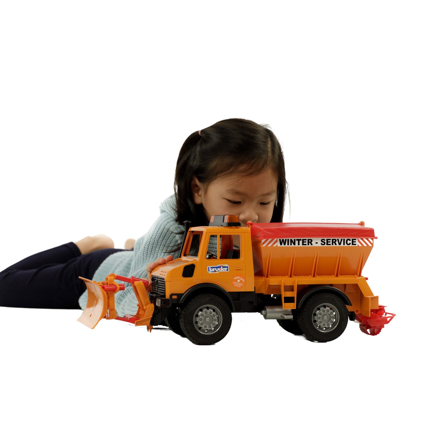 Child playing with orange Bruder winter service truck toy featuring movable snow plow and salt spreader in remote controlled toys collection