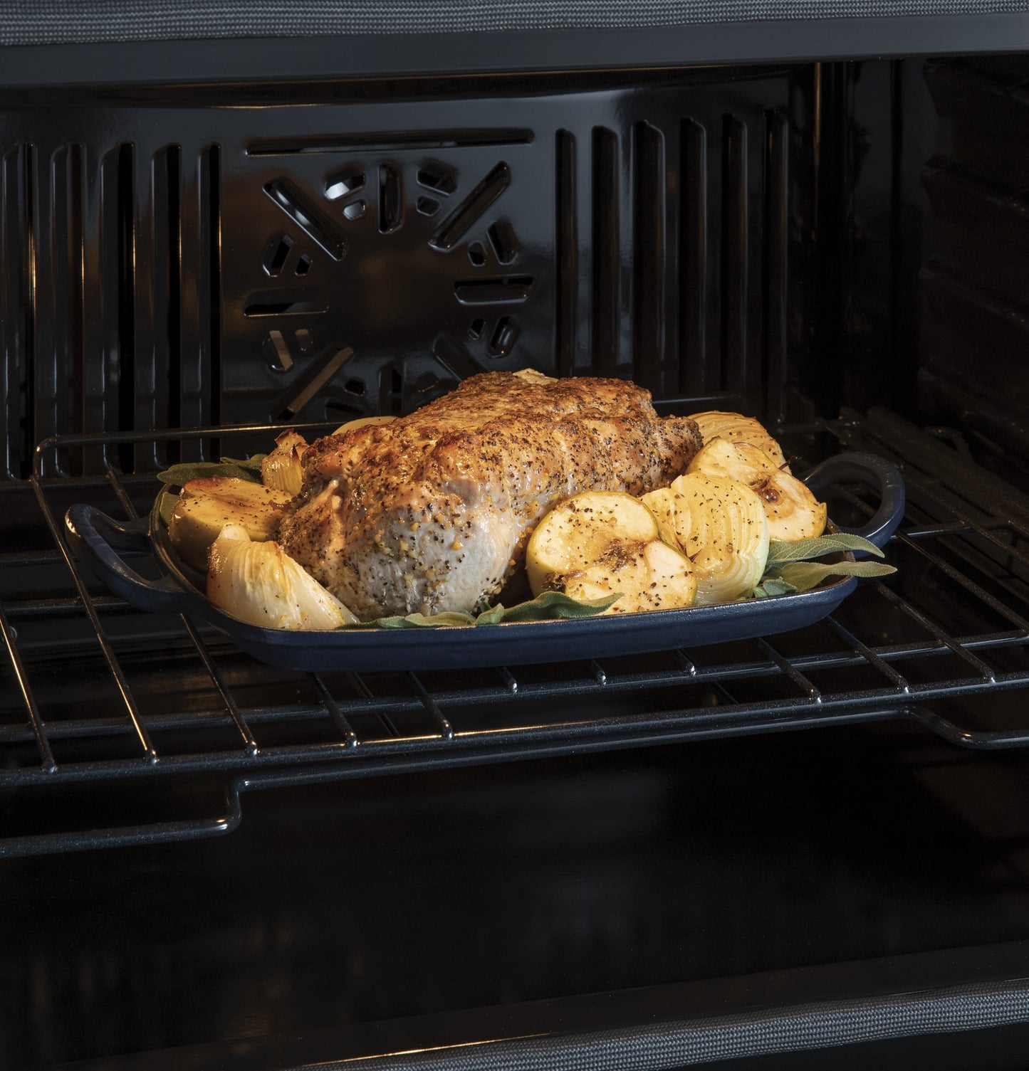 Roast chicken and seasoned vegetables cooking inside a convection wall oven from the Double Wall Ovens collection